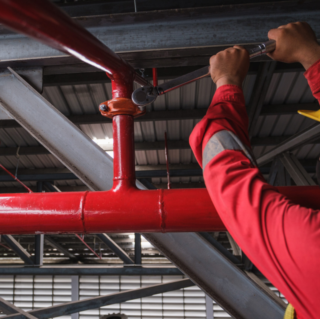 Certified fire sprinkler technician conducting repairs on a fire sprinkler system.